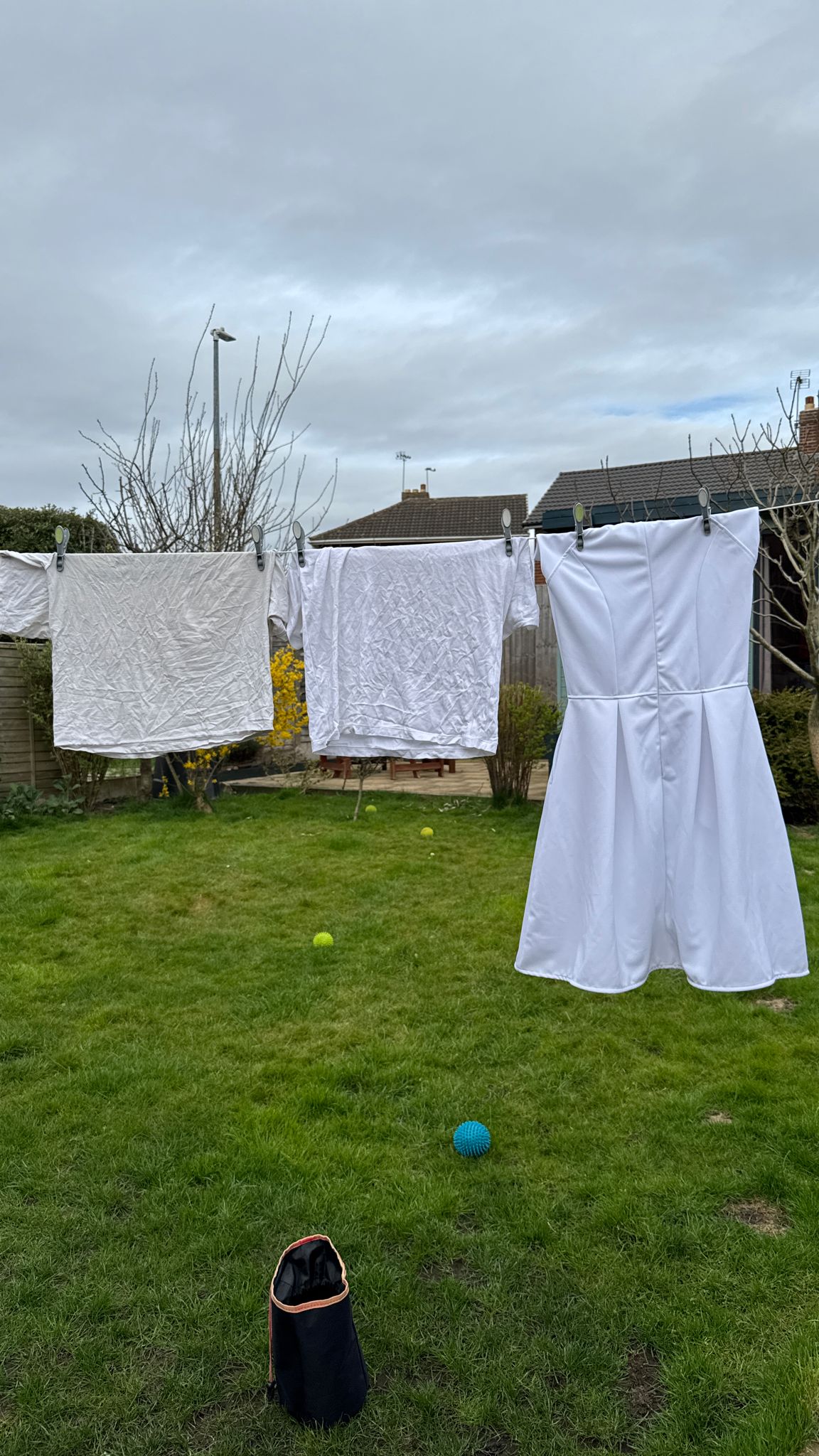 P’tit Affair midi dress prototype hanging next to a wrinkled premium T-shirt after washing—highlighting the difference in fabric performance and quality.