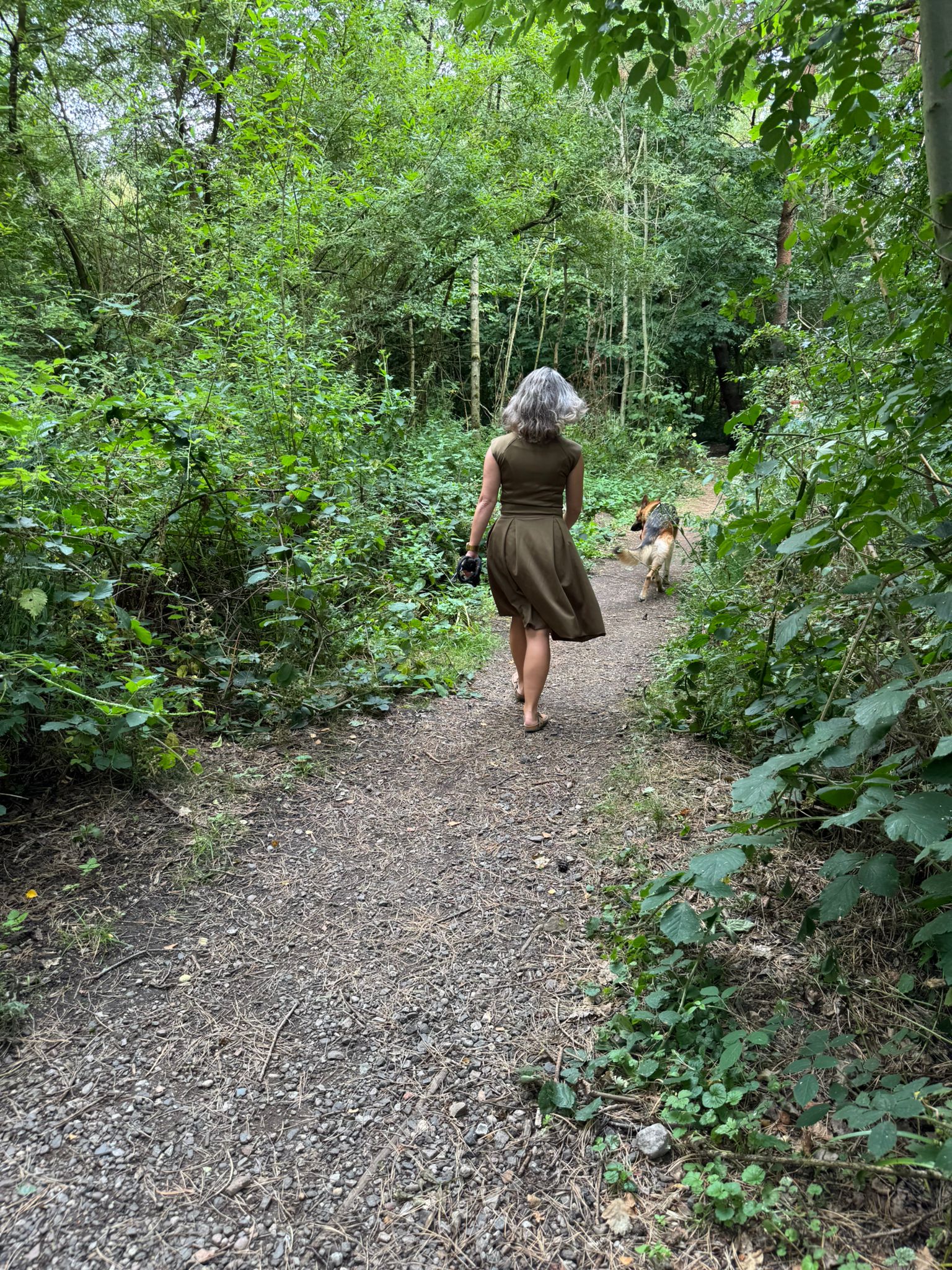 Su Dias walking in Sandwell Valley wearing an eloise Olive green midi dress from P'tit Affair and her dog Albus