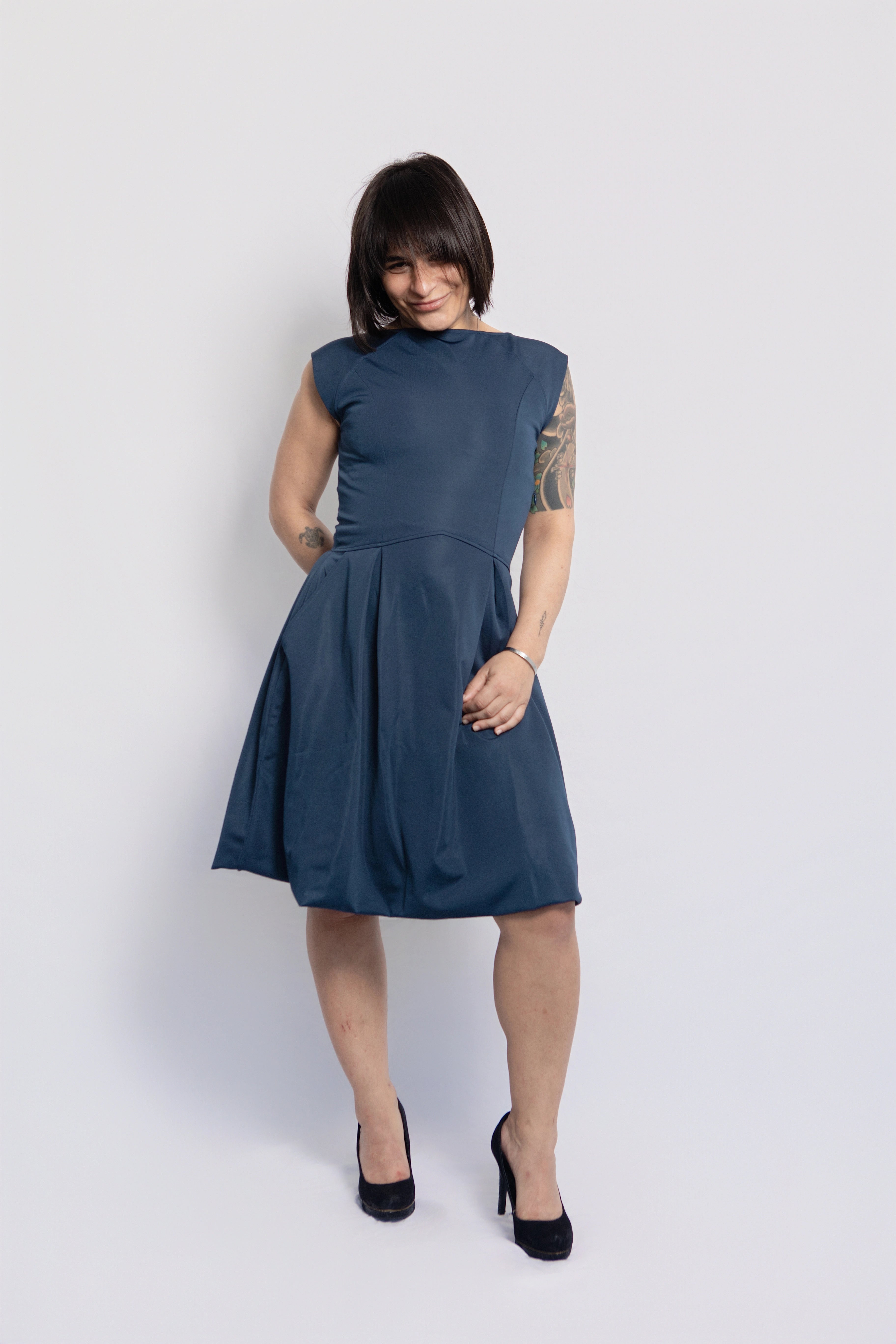 Petite woman wearing a blue midi dress with black heels, styled for an elegant evening look. Timeless petite-friendly fashion for women 5'3 and under
